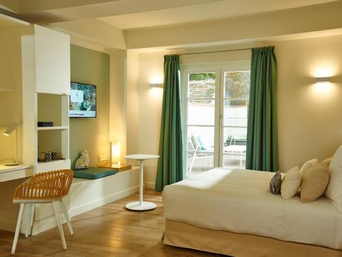 een slaapkamer met een bed, een tafel en een raam bij Hôtel de Cavoye in Fontainebleau