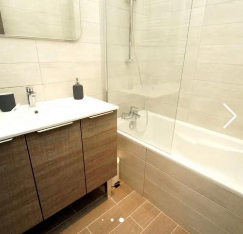 La salle de bains est pourvue d'une baignoire blanche, d'un lavabo et d'une baignoire. dans l'établissement Deux Alpes - Résidence aux pieds des pistes -8 pers, à Les Deux Alpes