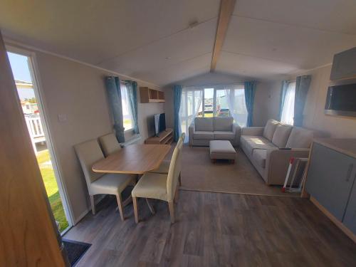 a living room with a table and a couch at Sophie's Caravan in Camber