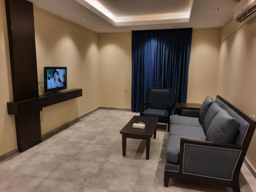 een wachtkamer met een bank en een tv bij شقق درر رامه للشقق المخدومة 11 in Riyad