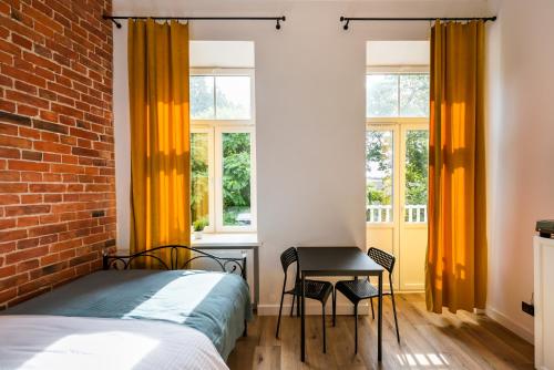 a bedroom with a bed and a desk and windows at National Stadium Cosy Studios in Warsaw