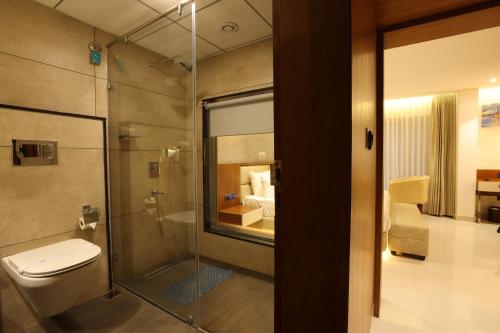 a bathroom with a toilet and a glass shower at Royal Plaza Suites in Mangalore