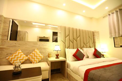 ein Hotelzimmer mit 2 Betten und einem Spiegel in der Unterkunft Hotel Amrit Villa Karol Bagh New Delhi - Couple Friendly in Neu-Delhi