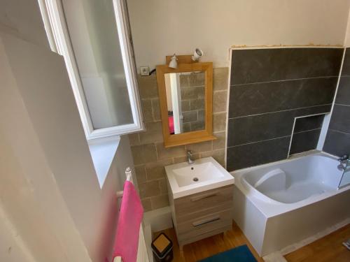 La salle de bains est pourvue d'un lavabo, de toilettes et d'un miroir. dans l'établissement Maison de ville au cœur de Saint Pierre en Auge, à Saint-Pierre-sur-Dives