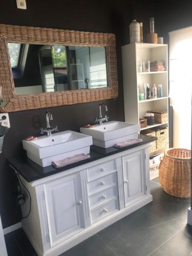 a bathroom with two sinks and a mirror at A l'orée du bois "maison de vacances" in Spa