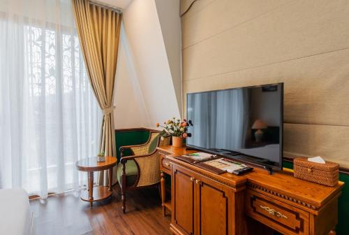 a room with a television and a desk with a mirror at Boutik Cham NhaTrang Hotel in Nha Trang