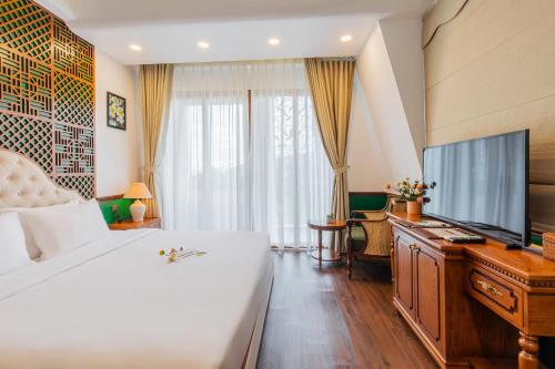 a bedroom with a large bed and a television at Boutik Cham NhaTrang Hotel in Nha Trang