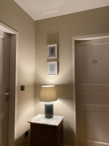 a lamp sitting on a table next to a door at Das Anni's in Wangerland