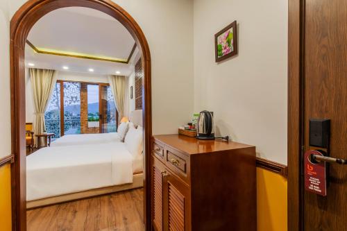 a bedroom with a bed and a mirror at Boutik Cham NhaTrang Hotel in Nha Trang