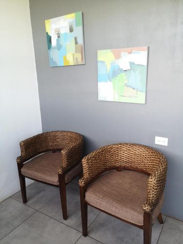 two wicker chairs sitting next to a wall at The Stay Inn in San José