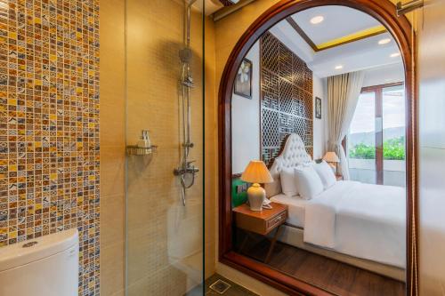 um quarto com uma cama branca e um chuveiro em Boutik Cham NhaTrang Hotel em Nha Trang