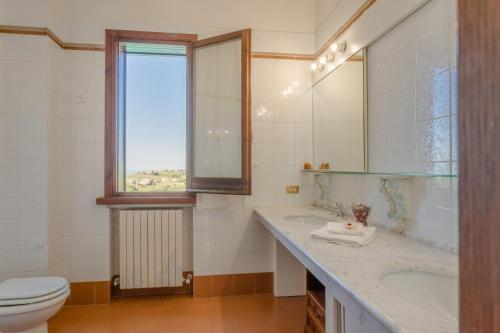La salle de bains est pourvue d'un lavabo, de toilettes et d'une fenêtre. dans l'établissement Villa Rosè - Natura vista mare - Narramondo Villas, à Cologna