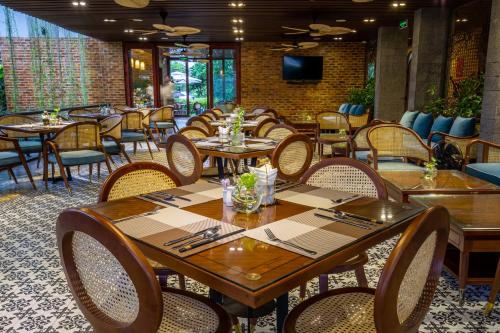 a dining room with wooden tables and chairs at Boutik Cham NhaTrang Hotel in Nha Trang