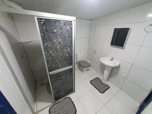 ein Badezimmer mit Dusche, Toilette und Waschbecken in der Unterkunft Linda casa com banho natural em Guaramiranga in Guaramiranga