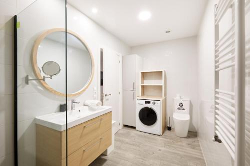 a bathroom with a sink and a washing machine at TuApartamento Navarreria Loft in Pamplona