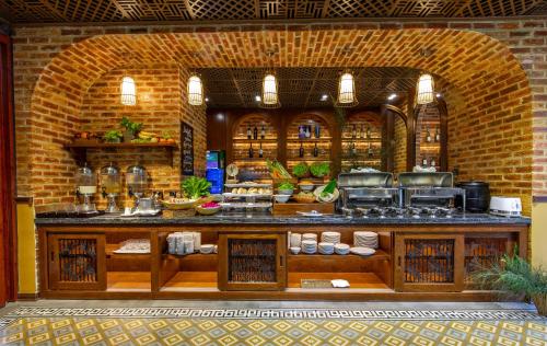 a kitchen with a brick wall and a counter with food at Boutik Cham NhaTrang Hotel in Nha Trang
