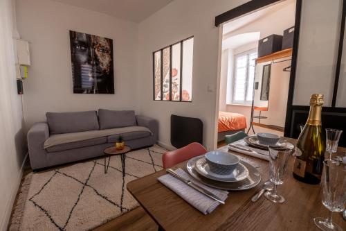 uma sala de estar com uma mesa e um sofá em Appartement Cosy avec Jardin au Centre Historique de Sélestat & Proche Europa-Park em Sélestat