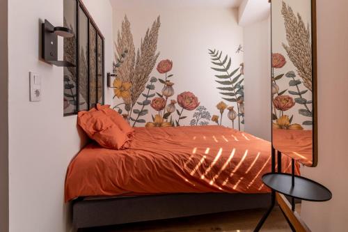 um quarto com uma cama com lençóis laranja e um espelho em Appartement Cosy avec Jardin au Centre Historique de Sélestat & Proche Europa-Park em Sélestat