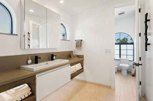 a white bathroom with a sink and a toilet at ModernCompound in Scottsdale