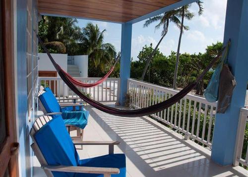 a porch with a hammock and chairs on a house at Laura's Lookout in Caye Caulker