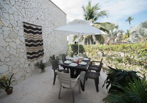 a table and chairs with an umbrella on a patio at Lago en el Cielo Villas Boutique in Tolú