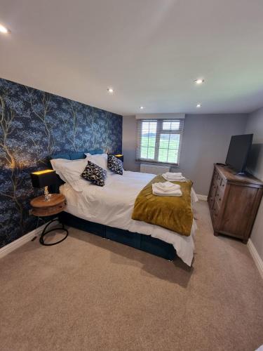 a bedroom with a large bed and a wooden dresser at Harewell wood cabin in Pateley Bridge