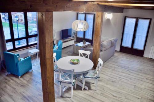 a living room with a table and chairs and a couch at Apartamentos La Ventana de Mogrovejo in Mogrovejo