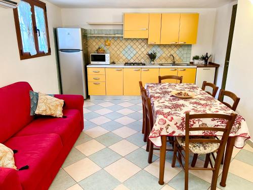 uma sala de estar com uma mesa e um sofá vermelho em Appartamento Le Ginestre em Monte Nai