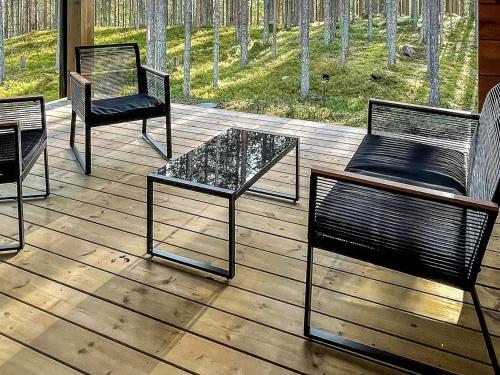 cztery krzesła i stół na drewnianym tarasie w obiekcie Holiday Home Tievachalets 6 b by Interhome w mieście Sirkka