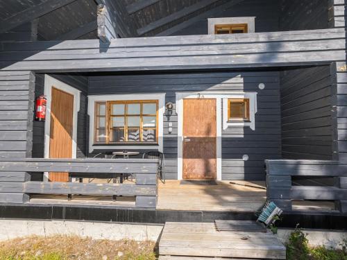ein blaues Haus mit einer Tür und einer Veranda in der Unterkunft Holiday Home Ruka-linkki 3a by Interhome in Ruka