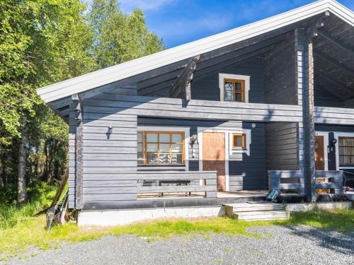 ein kleines blaues Haus mit einer Bank davor in der Unterkunft Holiday Home Ruka-linkki 3a by Interhome in Ruka