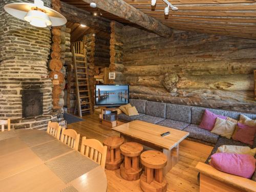 a living room with a table and a tv in a log cabin at Holiday Home Rantaruka 2c3 by Interhome in Ruka