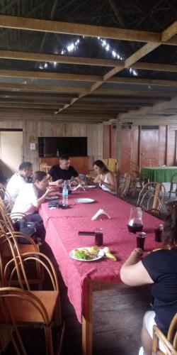 eine Gruppe von Menschen, die an einem langen Tisch sitzen in der Unterkunft Golden waters Lodges in Iquitos