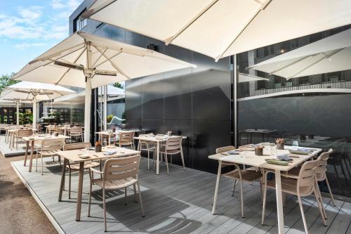 a restaurant with tables and chairs and umbrellas at INNSiDE by Meliá Luxembourg in Luxembourg