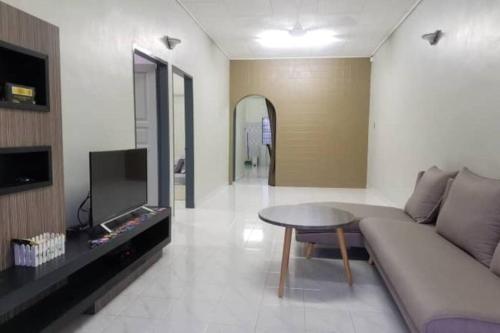 a living room with a couch and a table at Mersing Spacious 3bedroom with free parking space in Mersing
