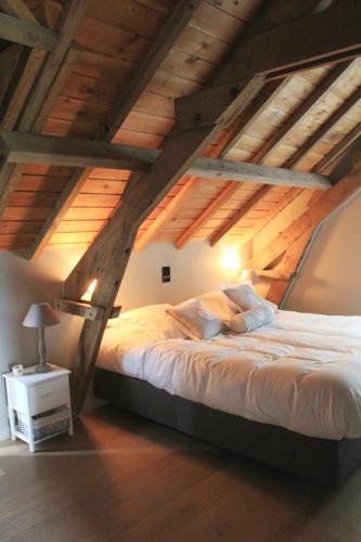 a bedroom with a large bed in an attic at B&B De Luyckhoek in Handzame