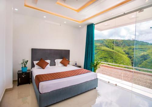 ein Schlafzimmer mit einem Bett und einem großen Fenster in der Unterkunft Hidden Valley Hill View Cottage Vagamon by VOYE HOMES in Vagamon