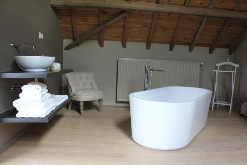 a bathroom with a white tub and a sink at B&B De Luyckhoek in Handzame