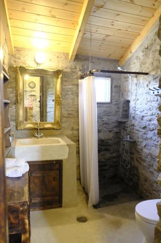 a bathroom with a sink and a mirror and a toilet at Hill's Barbacane in Potamós