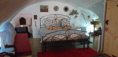ein Schlafzimmer mit einem großen Bett in einem Zimmer in der Unterkunft Studio atypique rue de Turin (ancienne étable de village) in Breil-sur-Roya