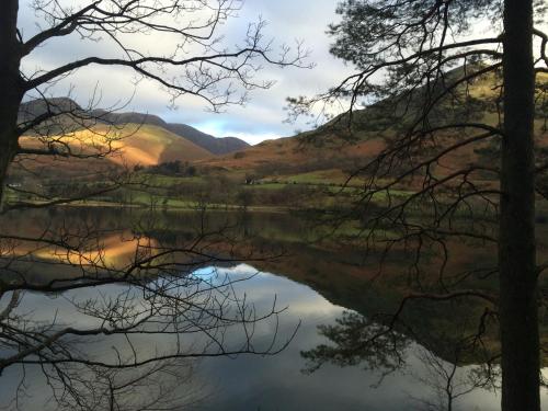 a view of a lake with trees and hills in the background at Luxury Cottage, views of the Lakes with Hot Tub in Cockermouth