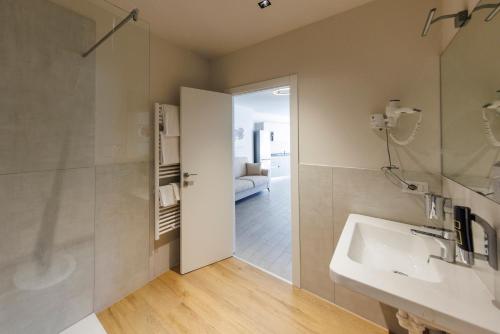a bathroom with a sink and a shower and a mirror at Exclusive Suites Riva in Riva del Garda