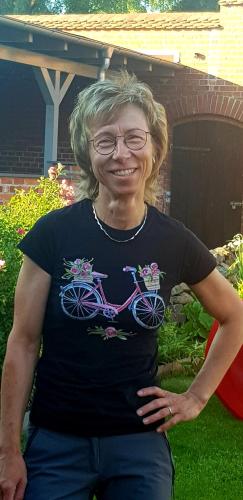 a woman wearing a black shirt with a bicycle on it at Pension Am Dorfanger in Hohennauen