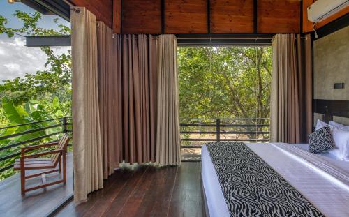 a bedroom with a bed and a large window at Atha Resort in Sigiriya