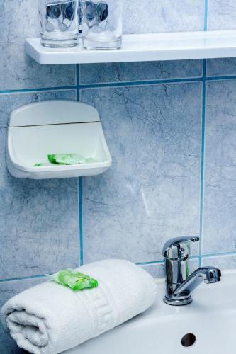 a bathroom sink with a towel next to a faucet at Hotel Riviera in Sinaia