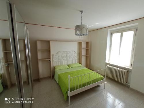 a bedroom with a bed with green sheets and a window at Interstellar in Aielli