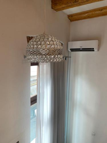 a chandelier hanging from a ceiling with a window at Latin Bridge Apartment Sarajevo in Sarajevo
