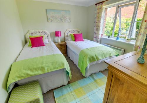 a bedroom with two beds and a window at Curlew Cottage in Langham