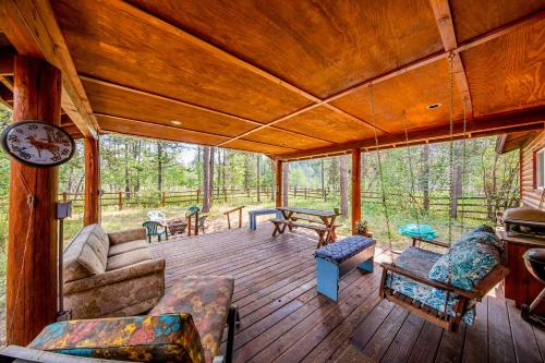a screened in porch of a cabin with a couch and chairs at Syringa House in McCall