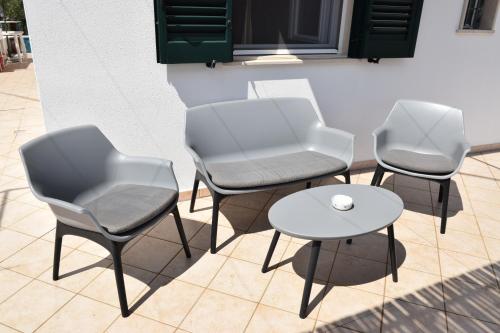 un grupo de sillas y una mesa en un patio en Mamma Maria Salento - Alle Macchie en Marina di Pescoluse